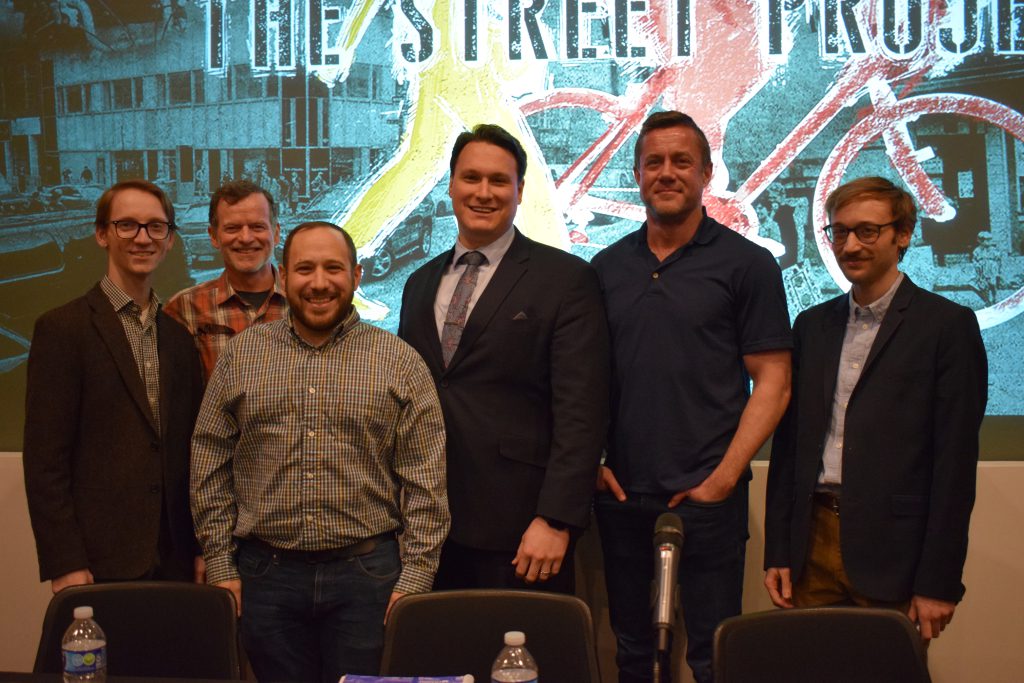 Six men standing in front of screen